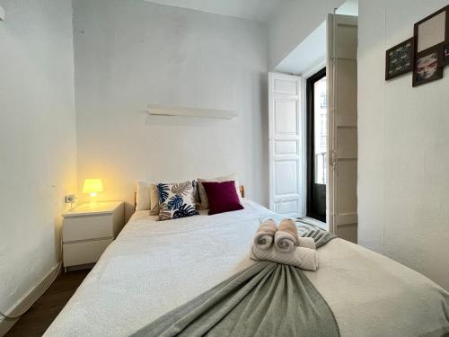 Un dormitorio con una cama con una toalla. en Ile Aina Exterior Nuevo Peña, en Madrid