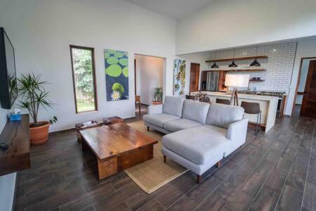 ein Wohnzimmer mit einem Sofa und einem Couchtisch in der Unterkunft Cheerful 2 bedroom Villa with Pool in Benque Viejo del Carmen