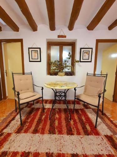 a living room with two chairs and a table at Casa de Danann in Rasquera