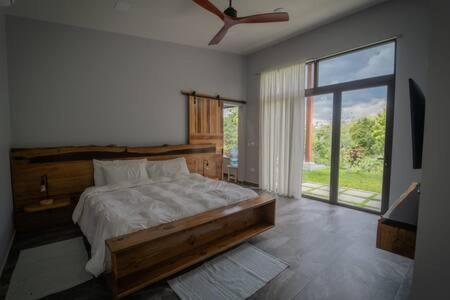 sypialnia z dużym łóżkiem i dużym oknem w obiekcie Modern Villa Overlooking Macal River Valley w mieście Benque Viejo del Carmen