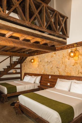 two beds in a room with wooden ceilings at Hotel El Cielo en la Tierra in Quimbaya