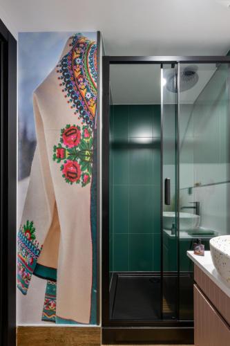 a bathroom with a shower with a painting on the wall at Harendzianka in Zakopane
