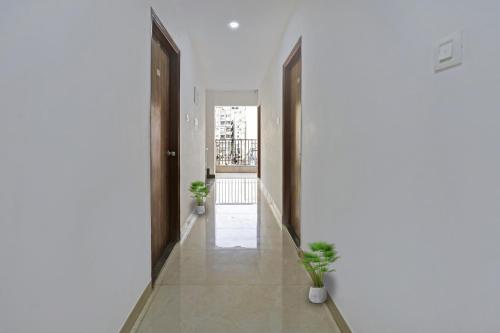 um corredor com dois vasos de plantas e duas portas em OYO Zois Nest em Kammasandra