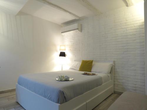 a white bedroom with a bed with a plate on it at Oberdan Apartment in Bologna