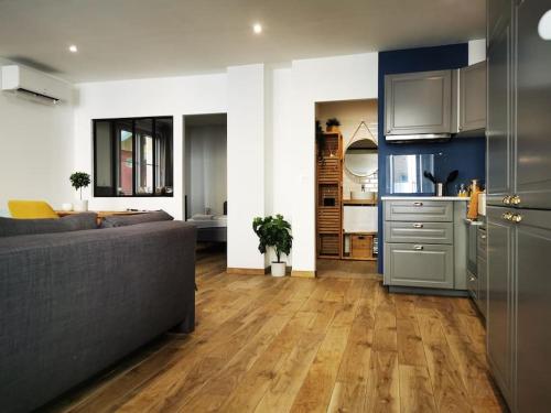 un salon avec un canapé et une cuisine dans l'établissement Appartement*Loft*Centre historique de SARLAT, à Sarlat-la-Canéda