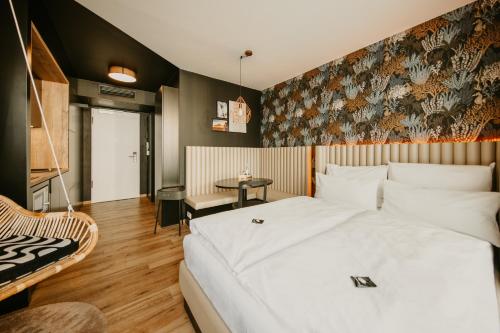 a bedroom with a large white bed and a chair at Rioca Hafeninsel Posto 8 in Offenbach