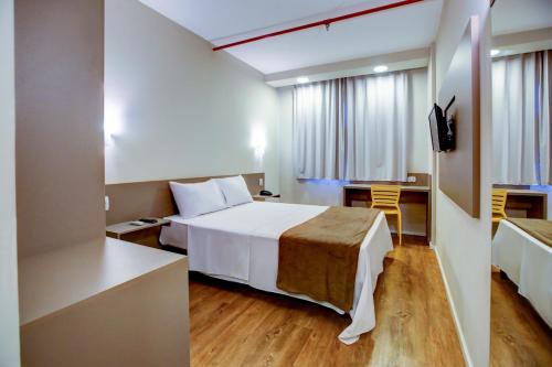 ein Hotelzimmer mit einem Bett und einem Schreibtisch in der Unterkunft Transamerica Fit Sorriso in Sorriso