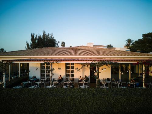 a building with people sitting outside of it at Prinsotel La Caleta in Ciutadella