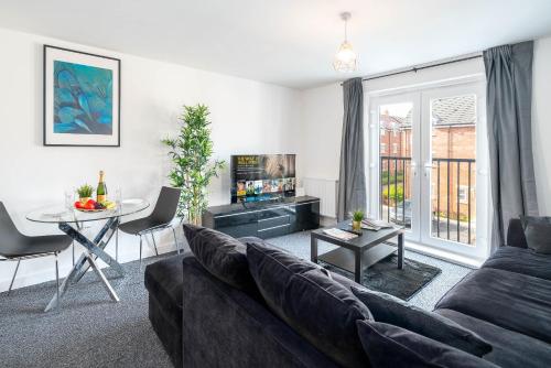 a living room with a couch and a table at Luxury Selly Oak Apartment near QE & Uni - Secure Parking - 20CC in Birmingham