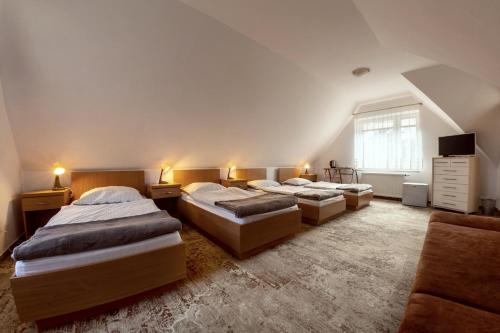 a bedroom with three beds and a couch at Pod Brzozą in Bydlino