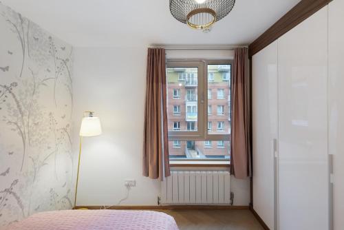 a bedroom with a bed and a window at 5-Star Kings Cross Home with Gym - Central London in London