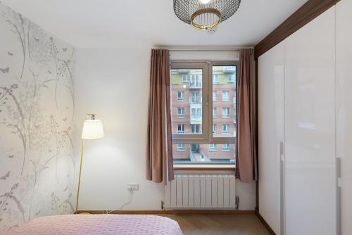 a bedroom with a bed and a window at 5-Star Kings Cross Home with Gym - Central London in London