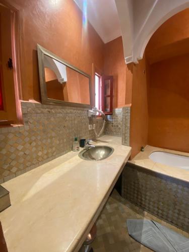 a bathroom with a sink and a bath tub at Riad Dar Teranga Hotel & Spa in Marrakech