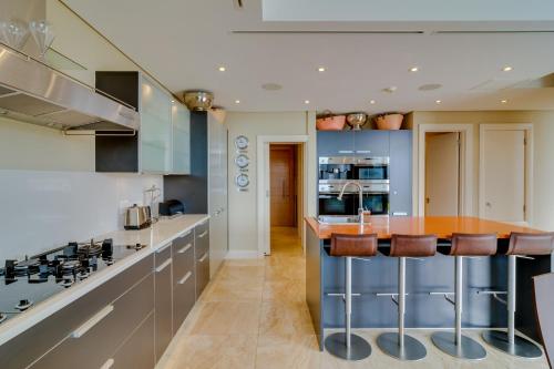 a kitchen with a island with bar stools at Mountain Marina Luxury Apartments in Cape Town