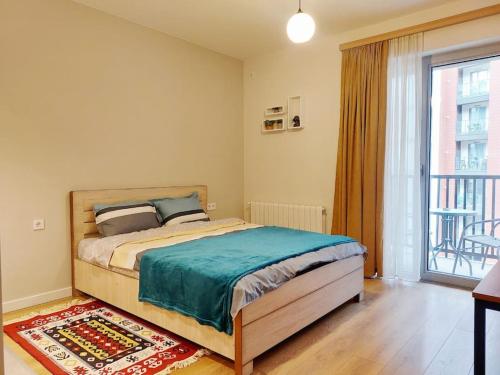 um quarto com uma cama e uma grande janela em Lovely Studio Apartment in M3 Saburtalo-District. em Tbilisi