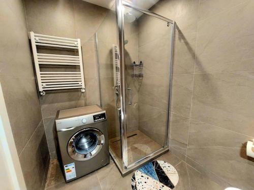 La salle de bains est pourvue d'une douche et d'un lave-linge. dans l'établissement Lovely Studio Apartment in M3 Saburtalo-District., à Tbilissi