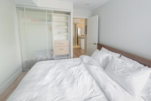 a bedroom with a white bed and a closet at Boutique Suite in Downtown Toronto, Free Parking! in Toronto