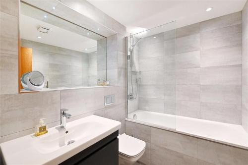 Newly Furnished Penthouse Mayfair في لندن: حمام مع حوض ومرحاض ومرآة