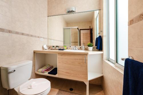 La salle de bains est pourvue de toilettes, d'un lavabo et d'un miroir. dans l'établissement Suenos del Mar II, à Playa Flamingo