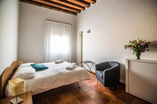 a bedroom with a bed and a chair and a window at Residence Montegrappa in Sandrigo