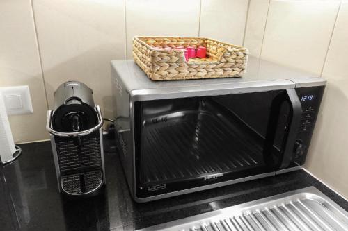 a microwave with a basket on top of it at ARISER - Zug Lake View Business Apartment in Zug