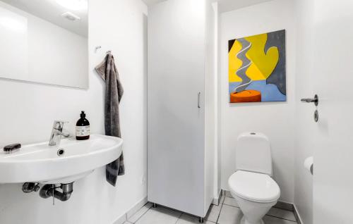 a white bathroom with a sink and a toilet at Holiday Home Næsvej Xi in Assens