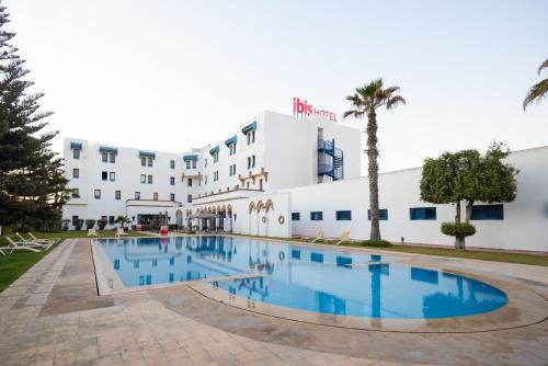 ein Hotel mit einem Pool vor einem Gebäude in der Unterkunft Ibis El Jadida in El Jadida