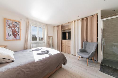 a bedroom with a large bed and a chair at Le Chemin de la Grave - Maison avec piscine in Aups