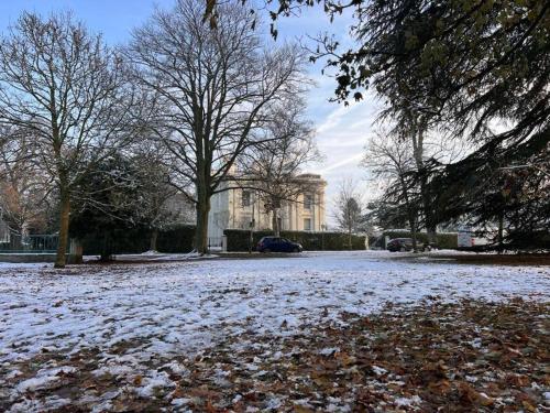 un parque cubierto de nieve con un edificio al fondo en Royal Regency Mansion - Maria Edgeworth Super King Room 