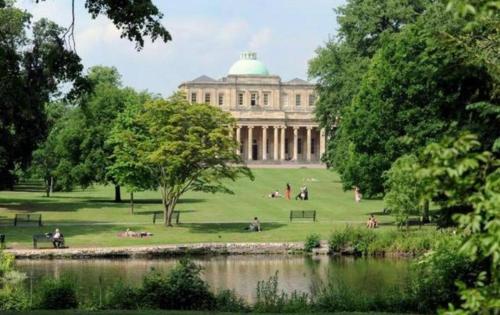 a building in a park with people sitting on the grass at Royal Regency Mansion - Maria Edgeworth Super King Room 