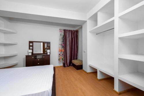 um quarto com prateleiras brancas e uma cama em Central Apartament Predeal Nr 1 em Predeal