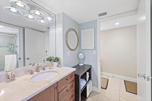 a bathroom with a sink and a mirror at Olde Marco riverfront condo with pools and tennis in Marco Island