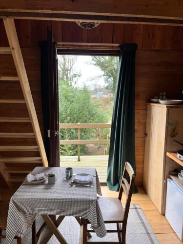 een tafel en stoelen in een kamer met een groot raam bij Cabane du Voyageur in Yvoir