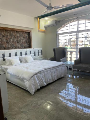 1 dormitorio con 1 cama grande y 2 sillas en BAHRIA HOLLIDAY HOME, en Rawalpindi