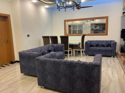 a dining room with two couches and a table at BAHRIA HOLLIDAY HOME in Rawalpindi