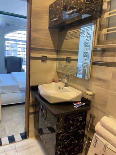 a bathroom with a sink and a mirror and a bed at BAHRIA HOLLIDAY HOME in Rawalpindi
