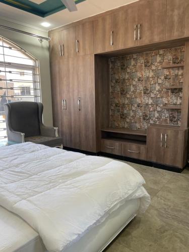 a bedroom with a large bed and a chair at BAHRIA HOLLIDAY HOME in Rawalpindi