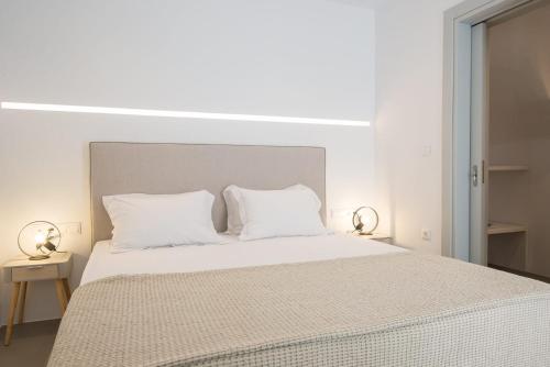 a white bedroom with a large bed with white pillows at Gorgeous Paros Villa - 3 Bedrooms - Villa Harmony - Private Outdoor Jacuzzi and Garden Views - Naousa in Livadia