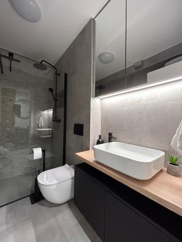 Un baño con un lavabo blanco y un inodoro. en Apartment Oris, Private Parking, Garden, en Zadar