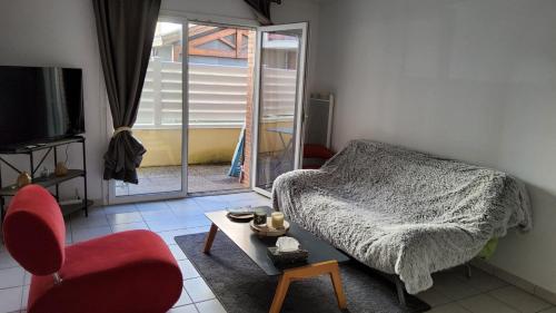 a bedroom with a bed and a table and a chair at Appartement, Lumières d'Arcachon in Arcachon