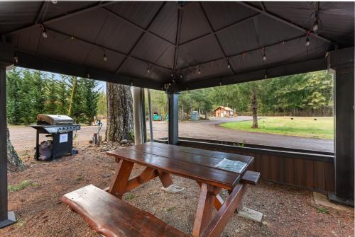uma mesa de piquenique e um banco debaixo de um guarda-chuva em The Entire Property at Mount Walker Inn em Quilcene
