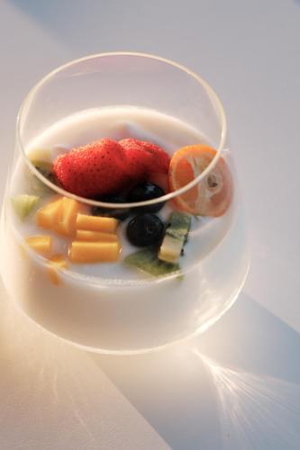 a bowl of fruit and vegetables on a white plate at Prinsotel La Caleta in Ciutadella