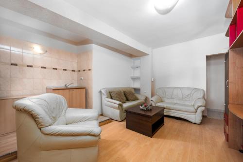 uma sala de estar com duas cadeiras e uma mesa de centro em Central Apartament Predeal Nr 1 em Predeal