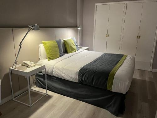 a bedroom with a bed with a table and a lamp at SuMa Recoleta Hotel in Buenos Aires