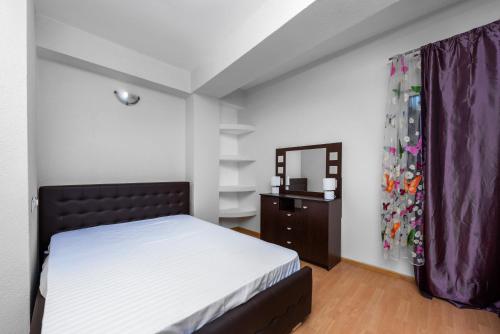 um quarto com uma cama, uma cómoda e um espelho em Central Apartament Predeal Nr 1 em Predeal