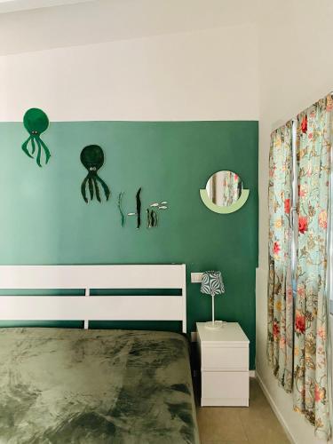 a bedroom with a bed and a green wall at Lupicante 56 Cesenatico in Cesenatico