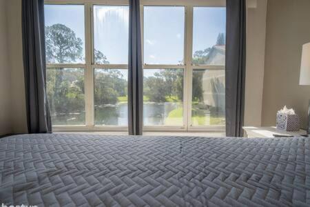 a bedroom with a large bed with a large window at Apartment for 6 very close to Disney in Orlando
