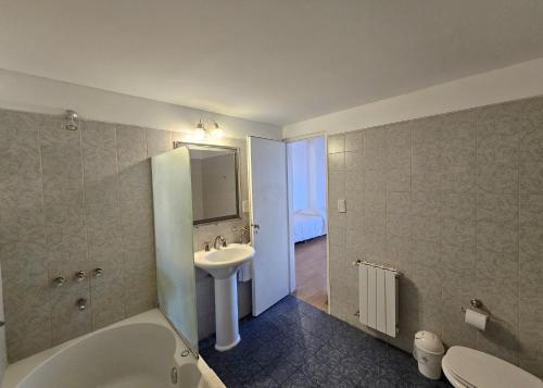 une salle de bain avec un lavabo, une baignoire et des toilettes dans l'établissement SH Hotel & Spa de Mar Samay Huasi, à Puerto Madryn