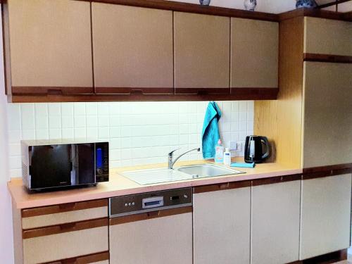 a kitchen with a microwave and a sink at Ferienwohnung Hölscher in Ascheberg
