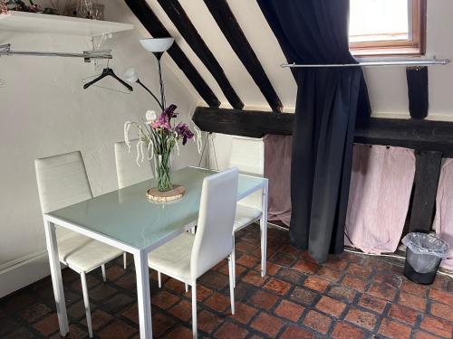 une table et des chaises avec un vase de fleurs. dans l'établissement Rue du poirier, à Orléans